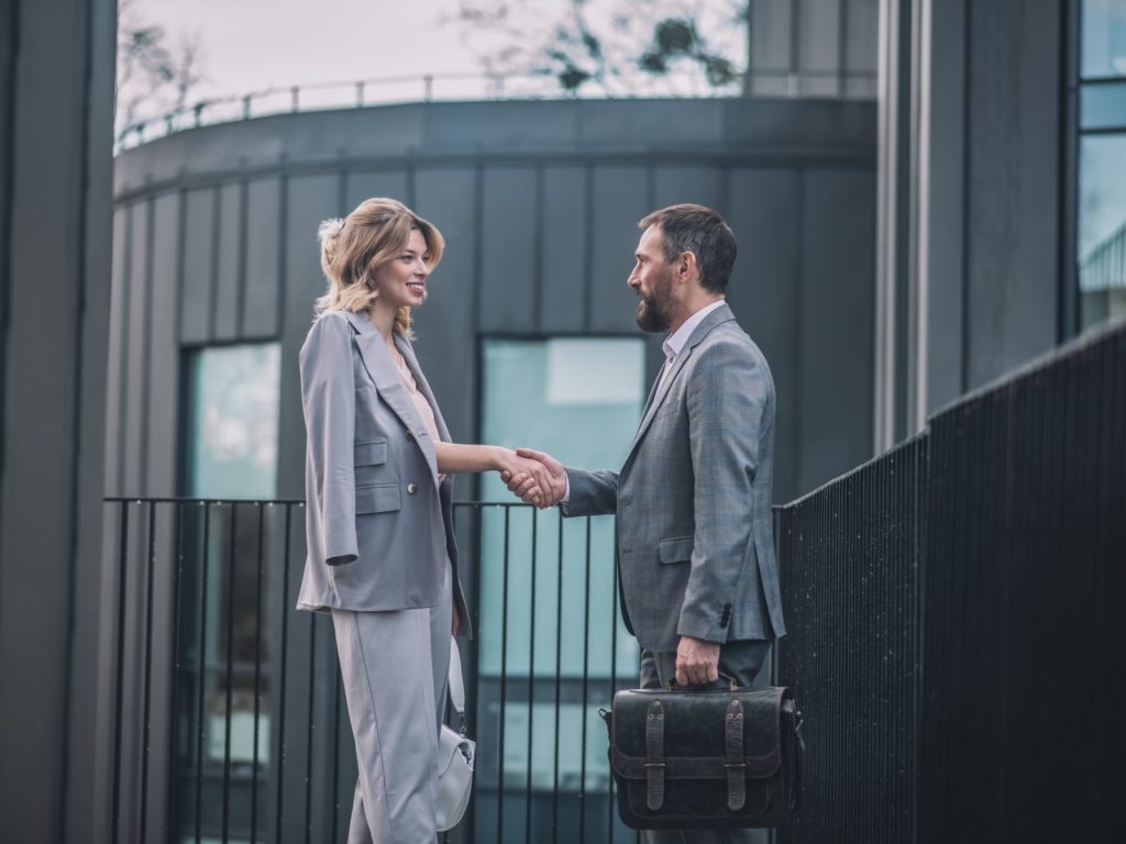 business man and business woman shaking hands