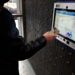 person using mvi keycom mounted on black wall