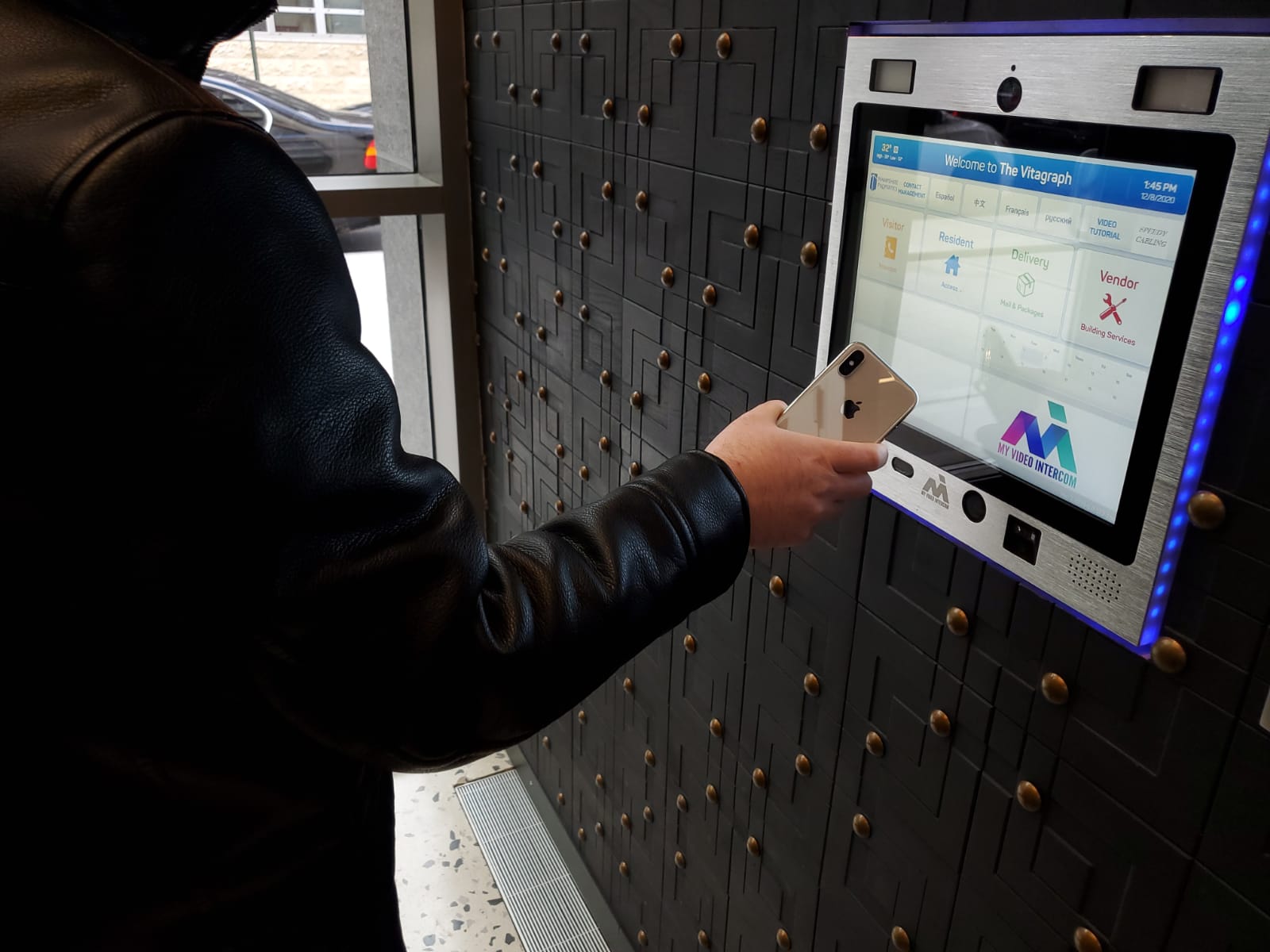 person using mvi keycom mounted on black wall