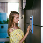 woman in yellow shirt using mvi keycom system to enter building