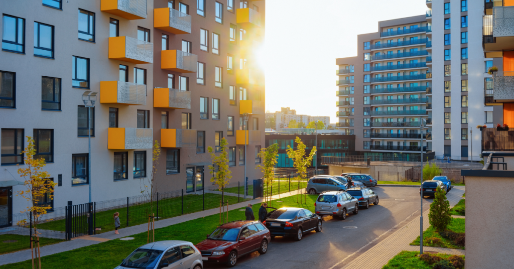 exterior of apartment complex with parked cars and residents