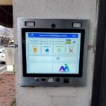 mvi keycom mounted on white stone wall by apartment building entrance