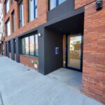 mvi keycom mounted on black wall next to building entrance