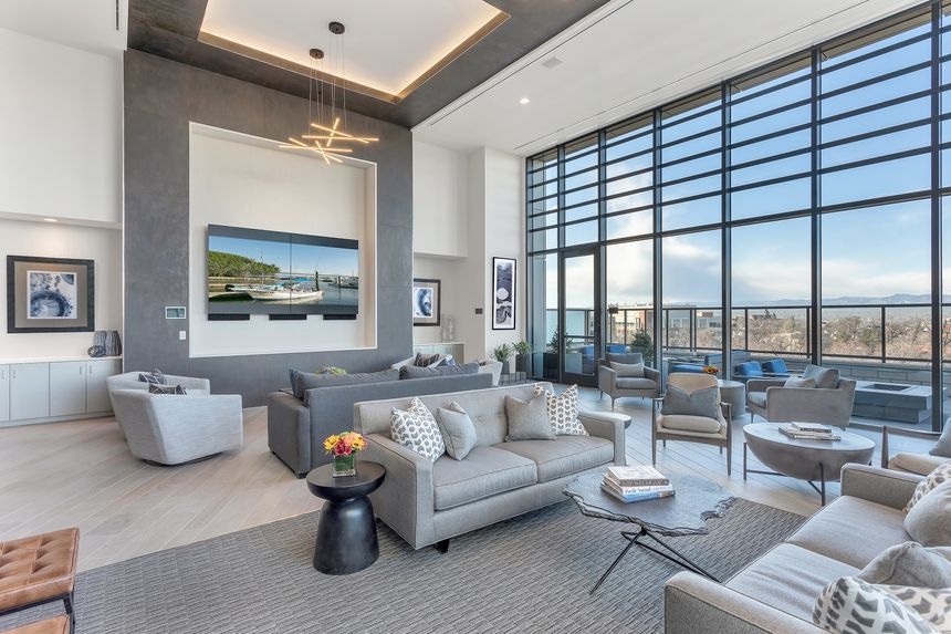 interior of apartment lobby filled with grey couches and chairs