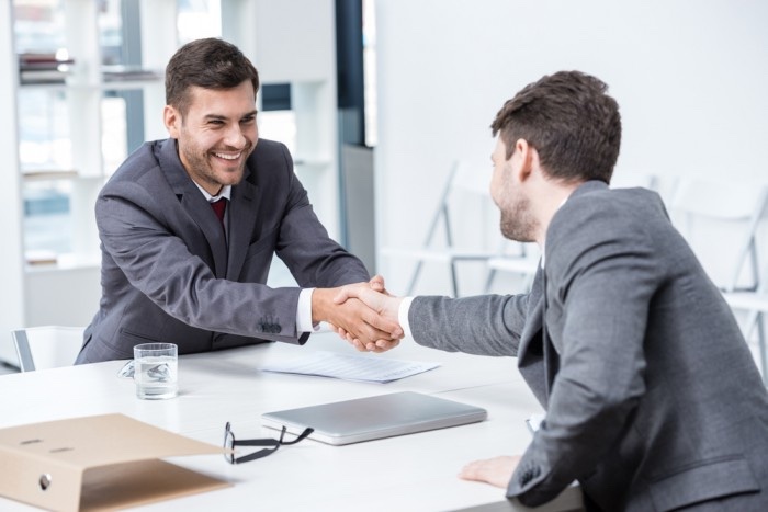 two business men in suits shaking hands