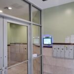 mvi keycom mounted on green and stone wall by building entrance