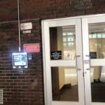 mvi keycom system mounted on brick wall by building entrance