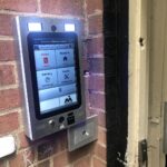 mvi keycom mounted on brick wall by building entrance