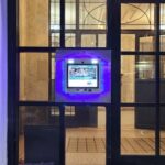 mvi keycom mounted on glass door by apartment building entrance