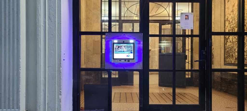 mvi keycom mounted on glass door by apartment building entrance