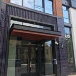 mvi keycom mounted on black wood wall by building entrance