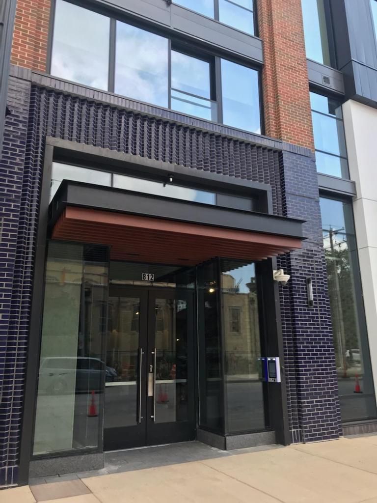 mvi keycom mounted on black wood wall by building entrance