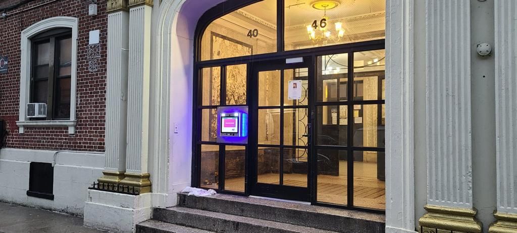 mvi keycom mounted on glass door by apartment building entrance