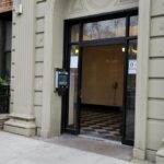 mvi keycom system mounted on white stone wall by building entrance