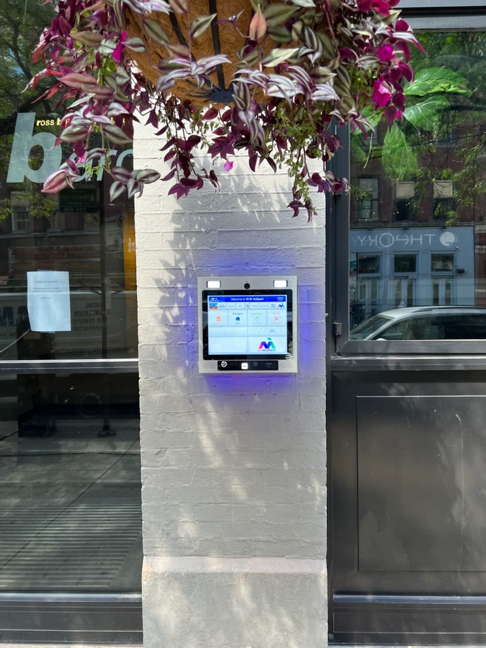 mvi access system installed on white brick column by building entrance