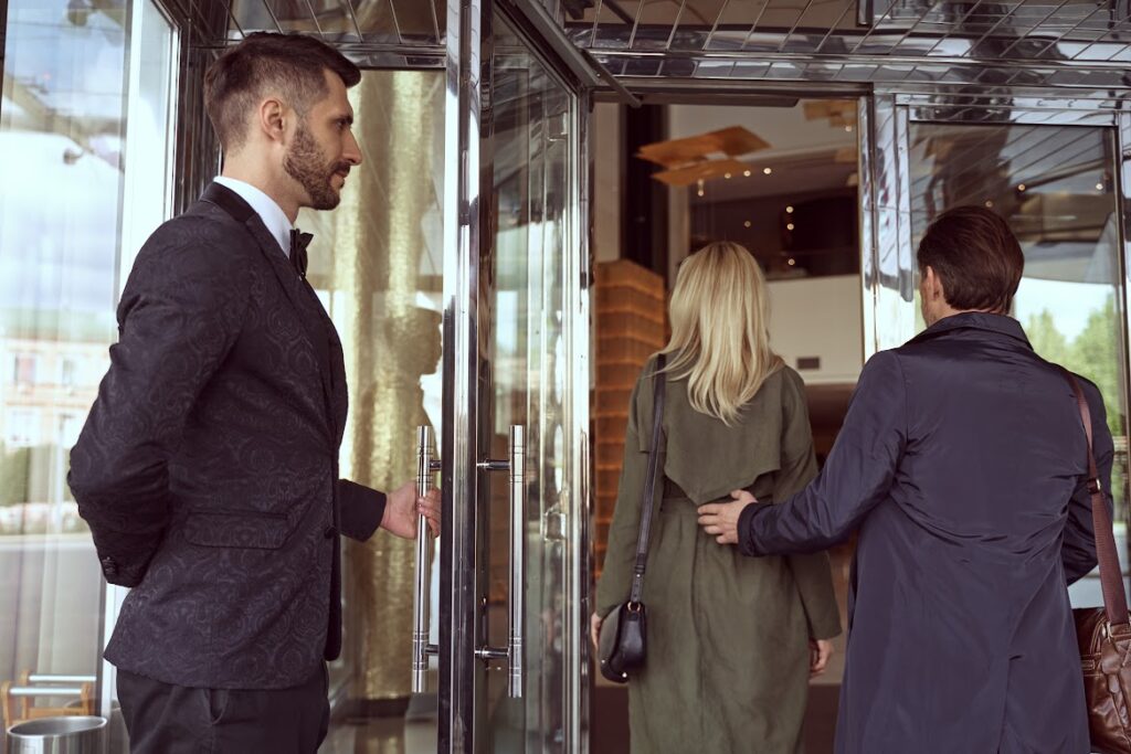 apartment complex doorman holding open door for couple
